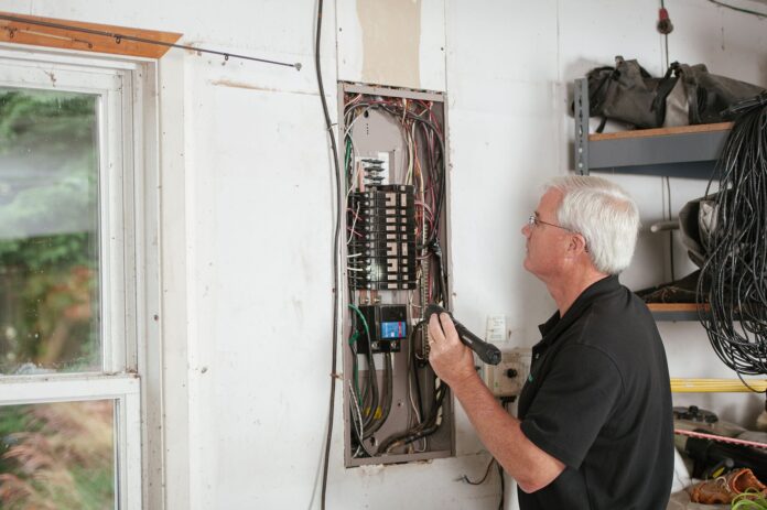 Elektryk sprawdzający domową rozdzielnicę elektryczną dla bezpieczeństwa