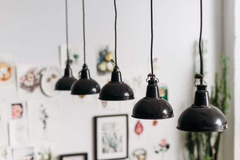 Rząd czarnych lamp wiszących w artystycznie urządzonym wnętrzu